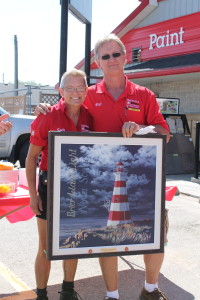 Sandy Harron and Bill Gillam with her painting, ‘The Brier Lighthouse'
