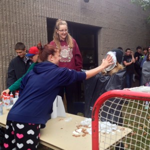 Students donated $1 to hit fly wheels off a bench. When they hit three of them off they had the opportunity to hit a teacher in the face with a pie. Here you can see Ms Godbold being a good sport when she takes one to the face by a student. All money collected from this activity will be going to the school's breakfast club.