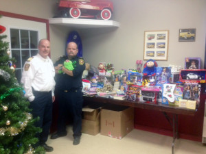 Photo by Michelle Janzen From left to right, Fire Chief Brad Lamaich and Captain Mike Morell stand beside the display of toys and non-perishable food items that they have collected to date.
